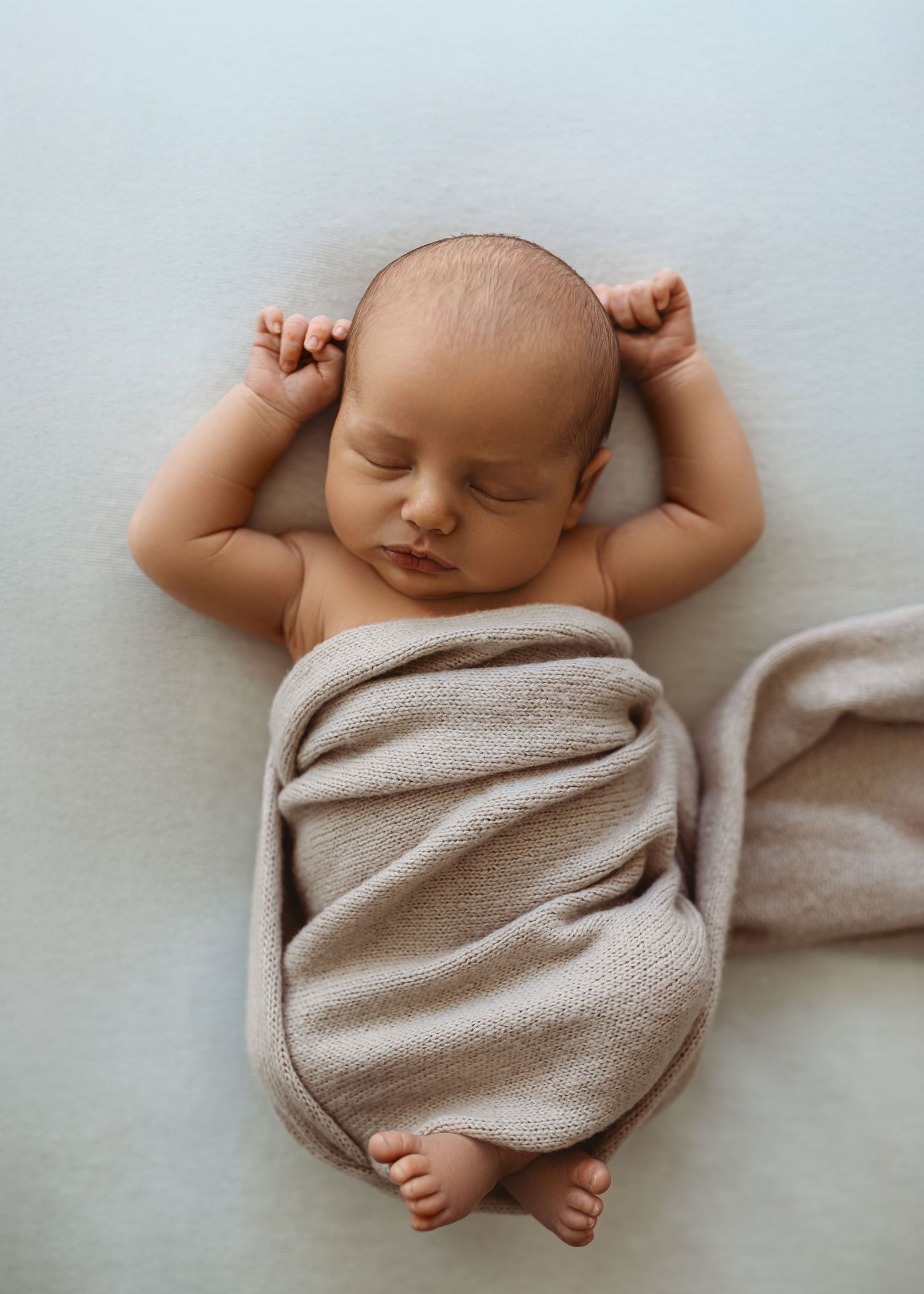 Newborn baby wrapped in knit blanket during studio session in Modesto, California