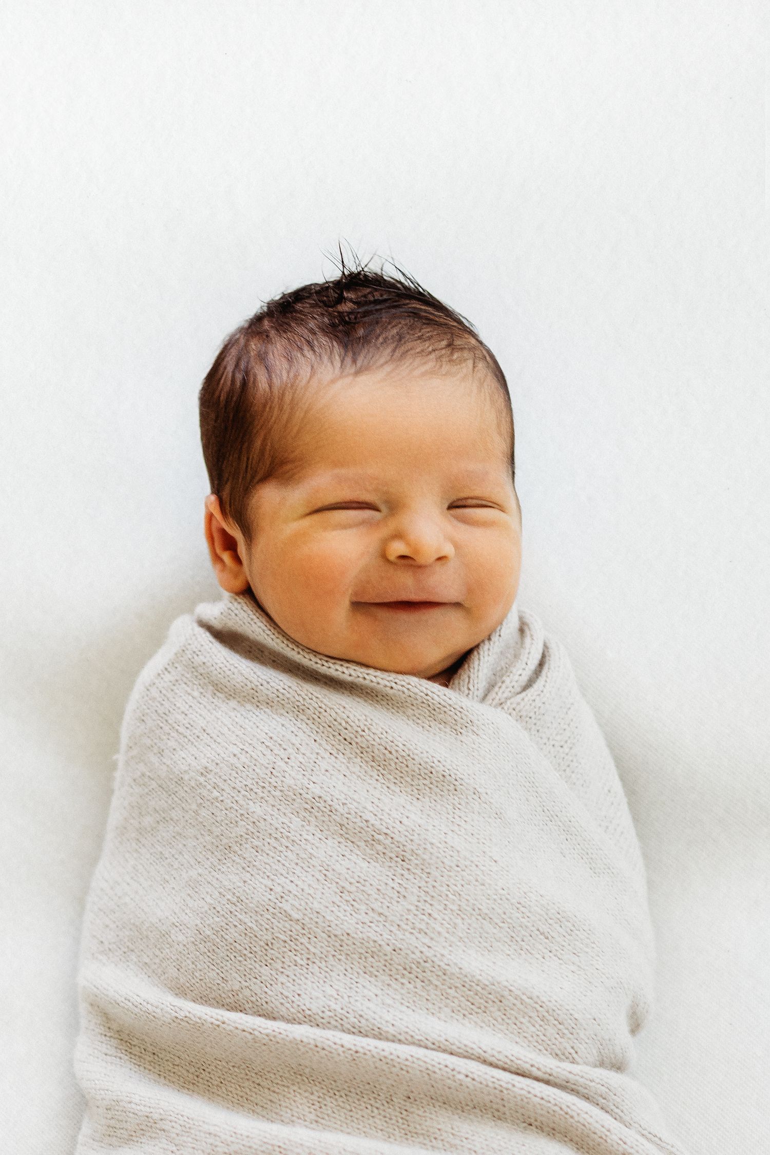 Newborn baby wrapped in knit blanket during studio session in Modesto, California