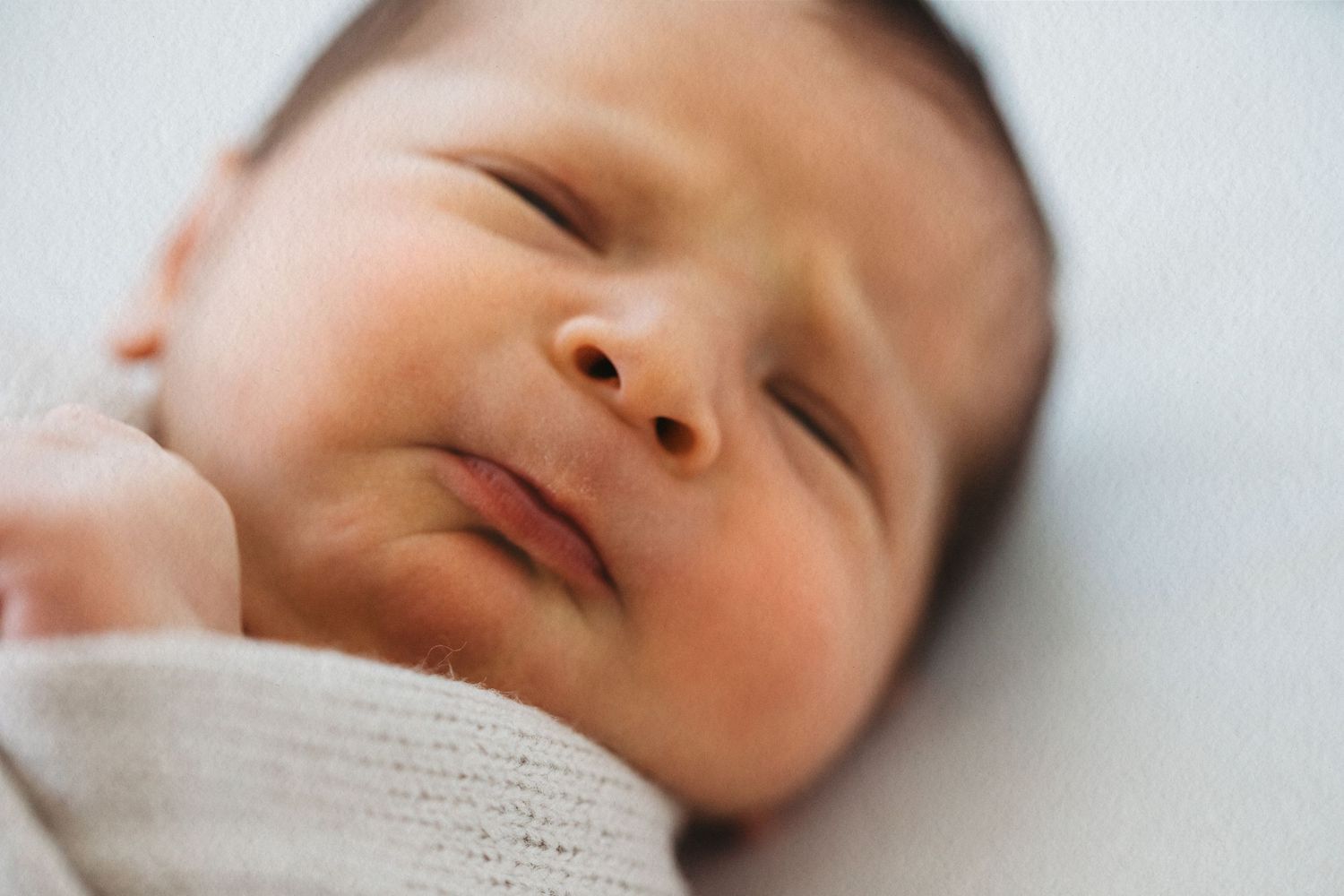 Newborn baby wrapped in knit blanket during studio session in Modesto, California