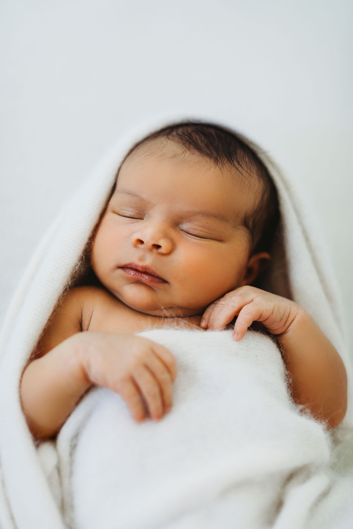Newborn baby wrapped in knit blanket during studio session in Modesto, California  Newborn Photographer
