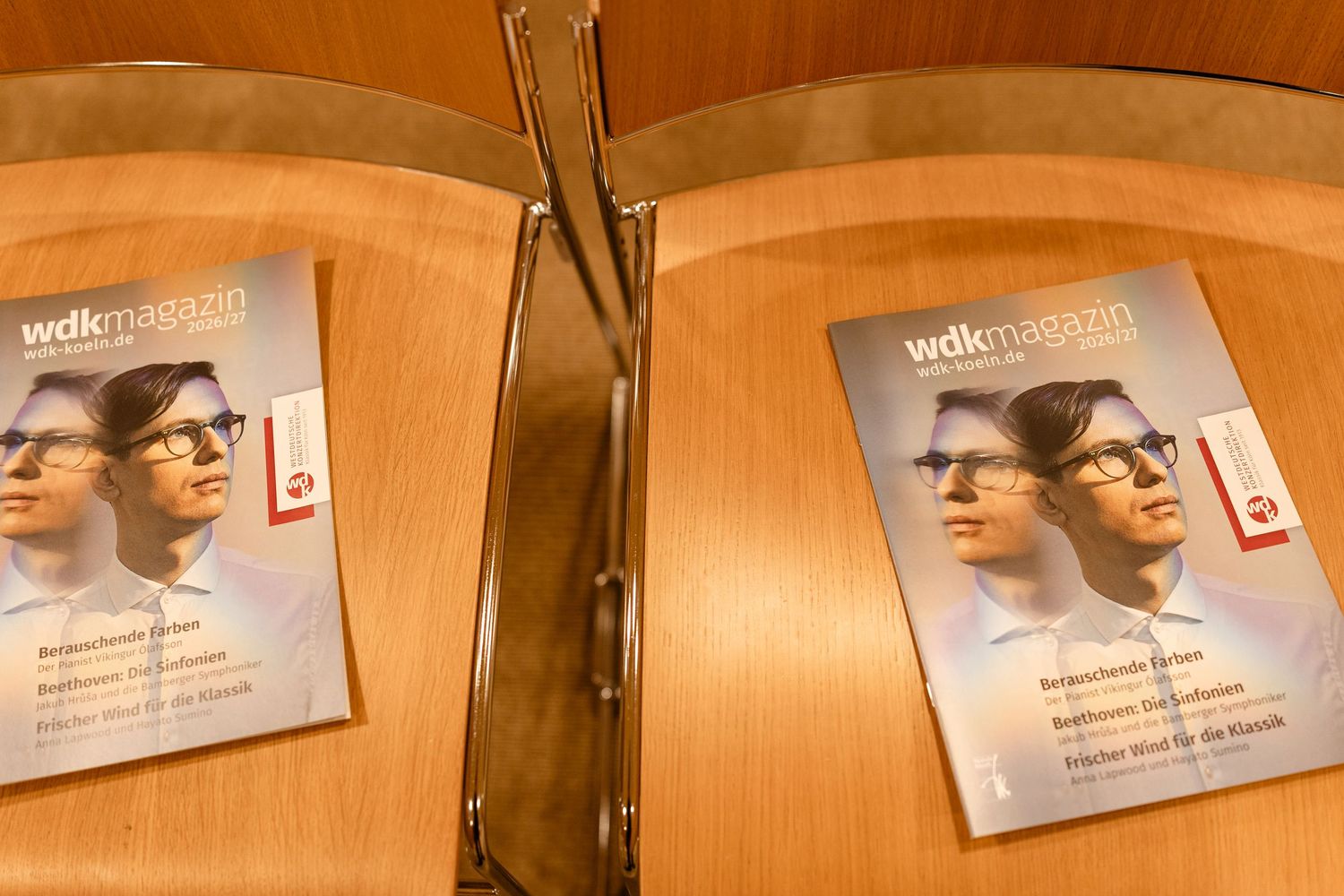 Two copies of WDK Magazin featuring a man wearing glasses displayed on a wooden surface.