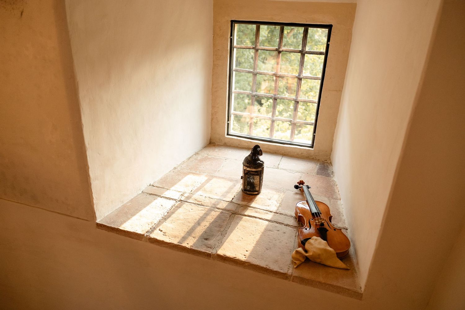 Room under renovation with bare plaster walls, concrete floor, and a large window letting in natural light.