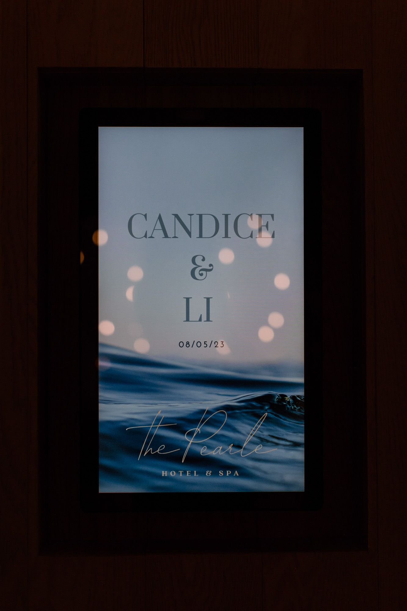 Elegant wedding sign for Candice and Li at The Pearl Hotel and Spa, dated 08/05/23, with ocean backdrop.