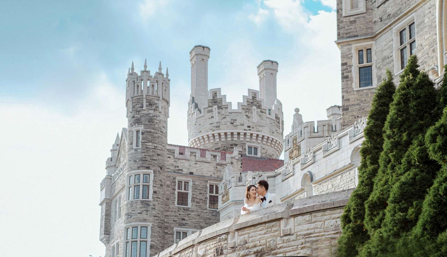 Bride and groom share a romantic moment on a castle balcony at Casa Loma.