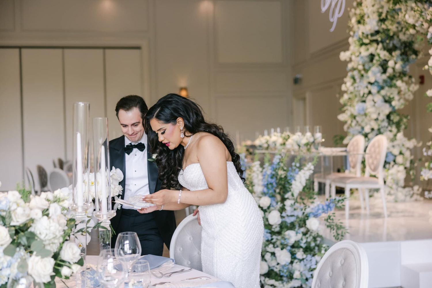 Bride and groom share a tender moment at beautifully decorated wedding sweetheart table.