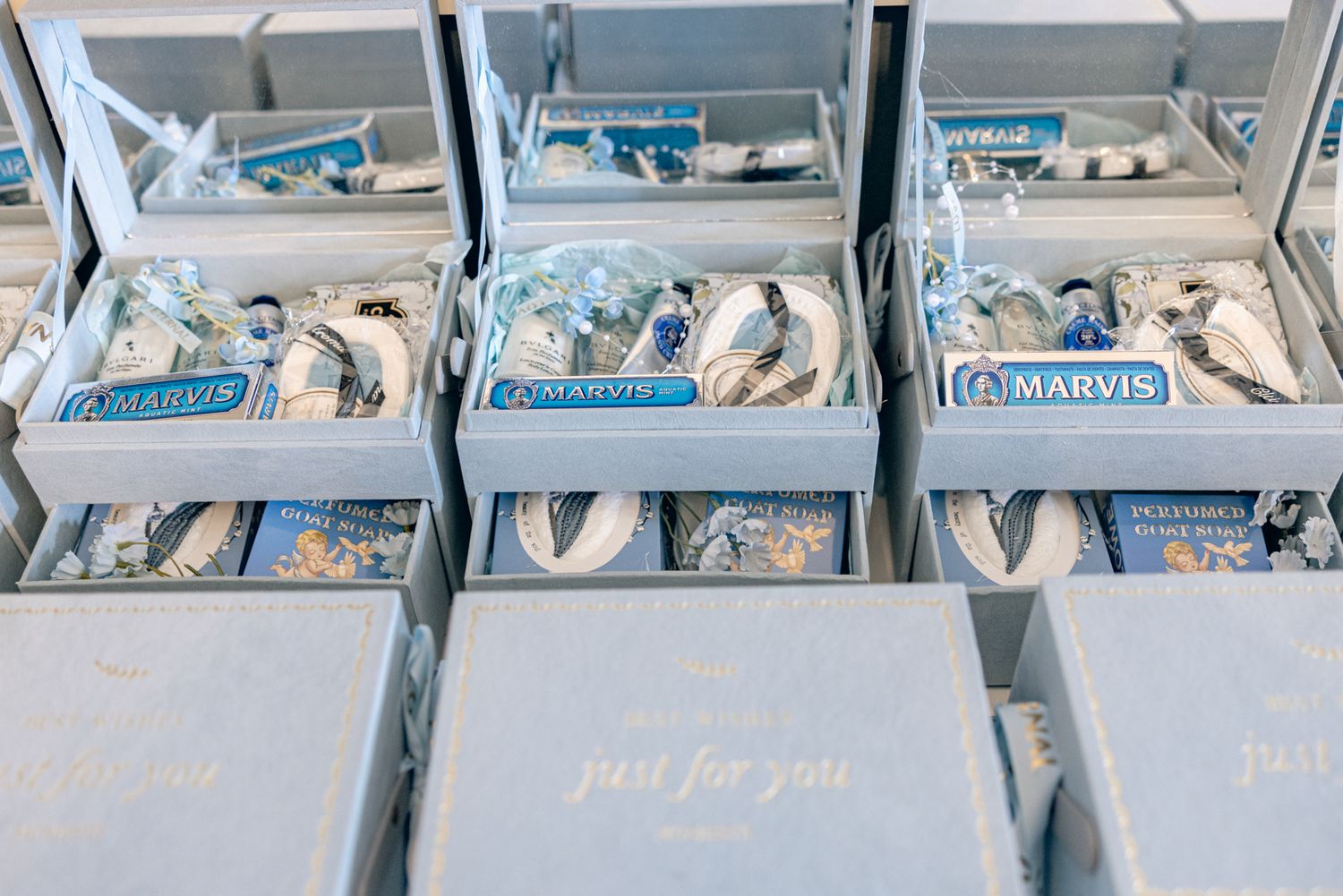 Blue gift boxes filled with Marvis toothpaste and accessories, labeled just for you, perfect for wedding favors.