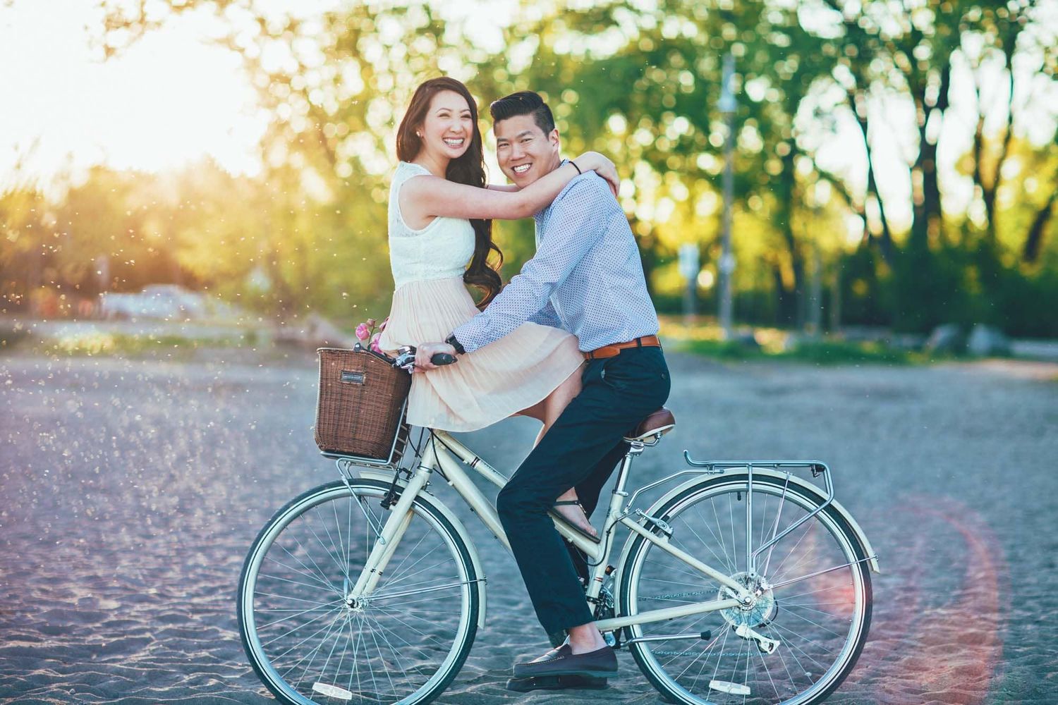 Happy couple sharing a bicycle ride at sunset in a scenic park.