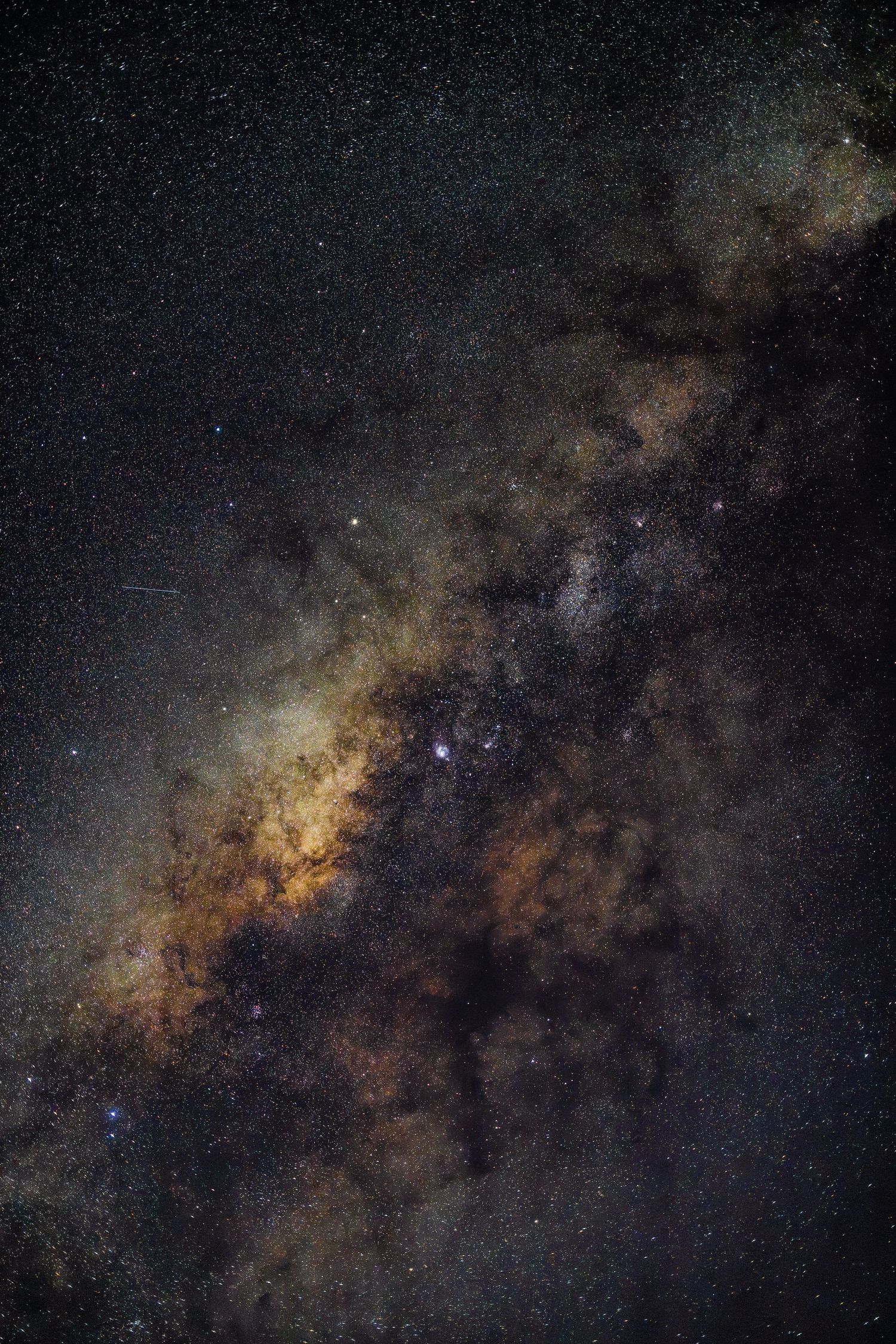 Stunning Milky Way galaxy core with golden dust clouds and thousands of stars in a deep night sky astrophotography shot.