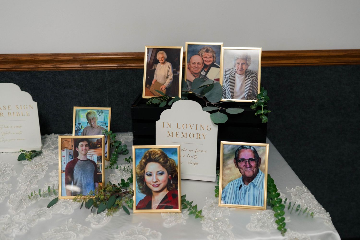 In Loving Memory wedding memorial table display with framed photos of loved ones.