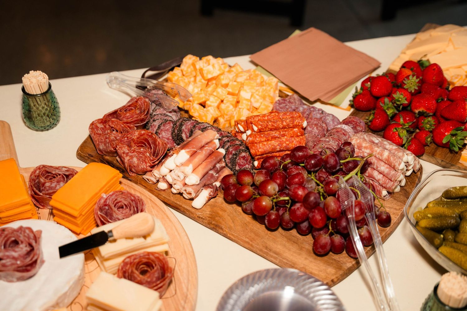 Elegant wedding charcuterie board with salami, cheese, grapes, strawberries, and assorted meats.