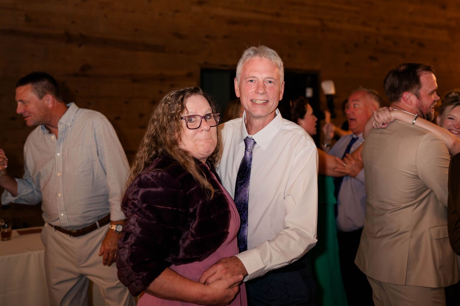 Couple smiling and embracing together on the dance floor at a wedding reception.