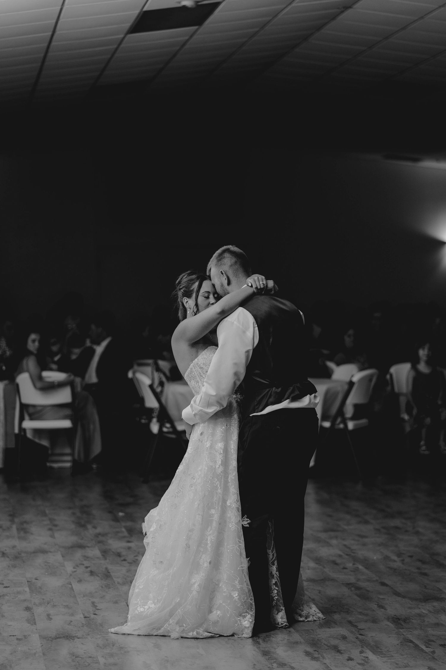 Bride and groom share emotional first dance at wedding reception.