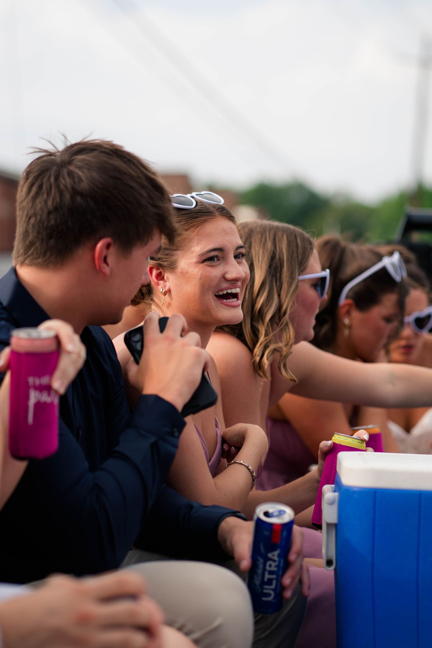 Joyful wedding guests laugh and celebrate outdoors during a lively summer wedding reception.