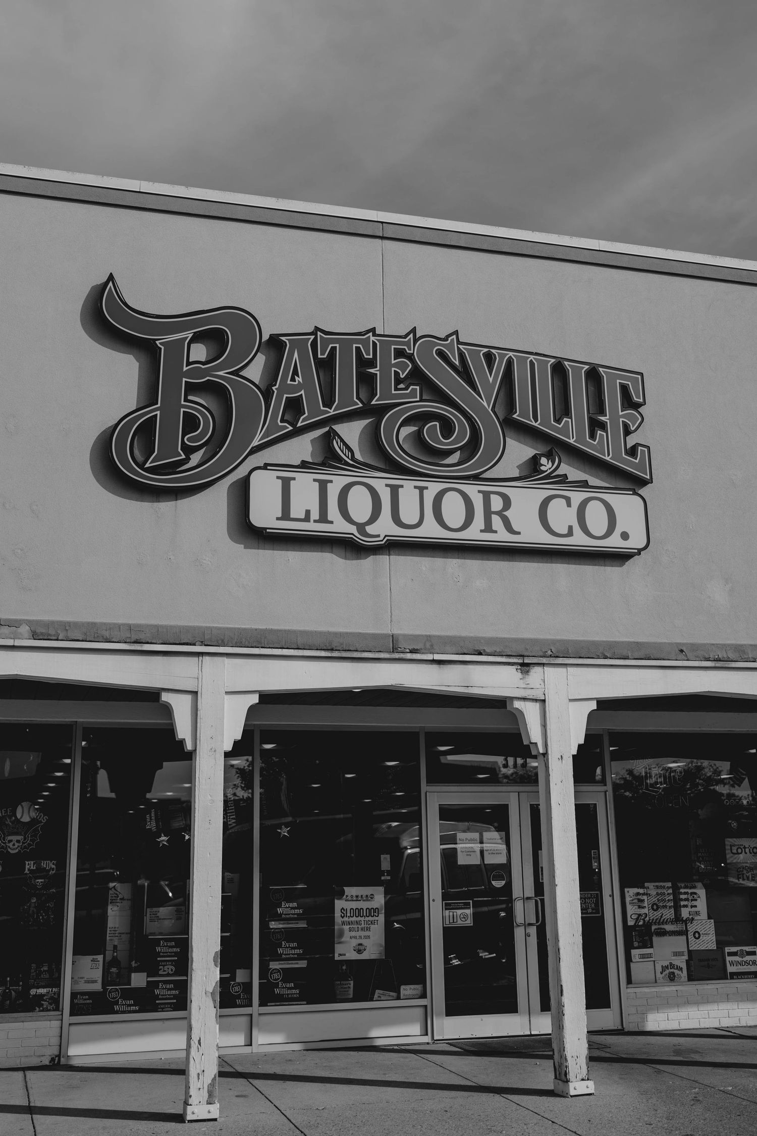Black and white exterior photo of Batesville Liquor Co. storefront with vintage-style signage.