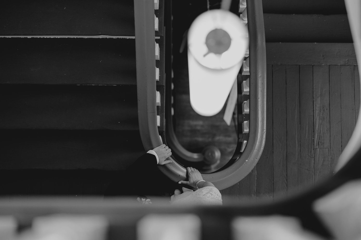 Black and white aerial view of an escalator handrail and mechanical components in motion.