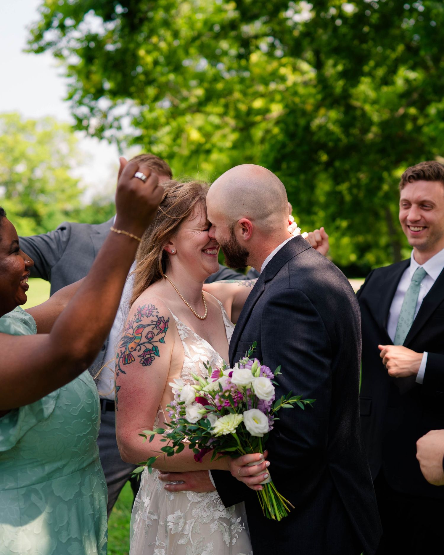 Bride and groom share a joyful moment surrounded by celebrating wedding guests.