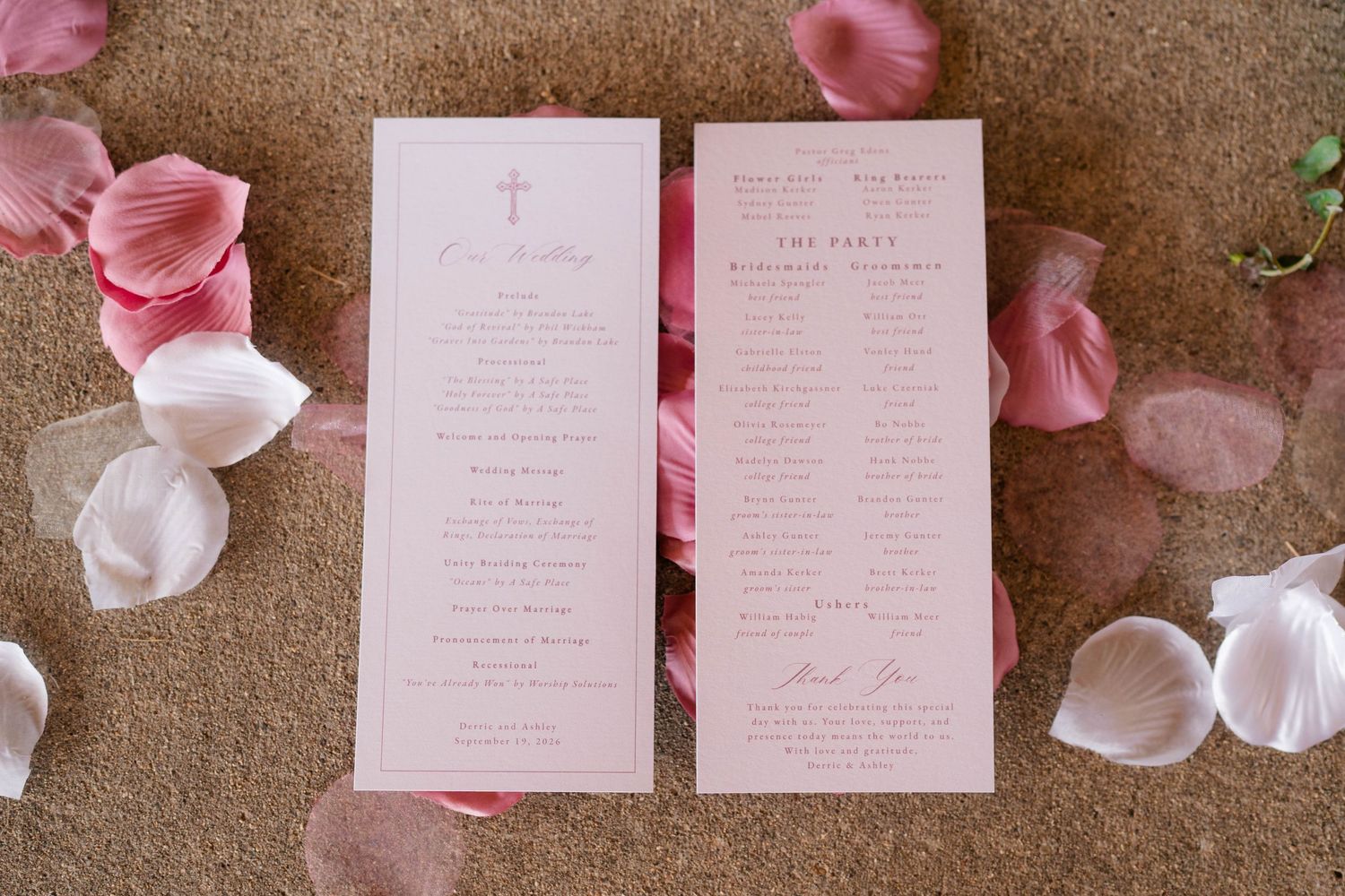 Elegant pink wedding ceremony program with cross design surrounded by scattered rose petals.