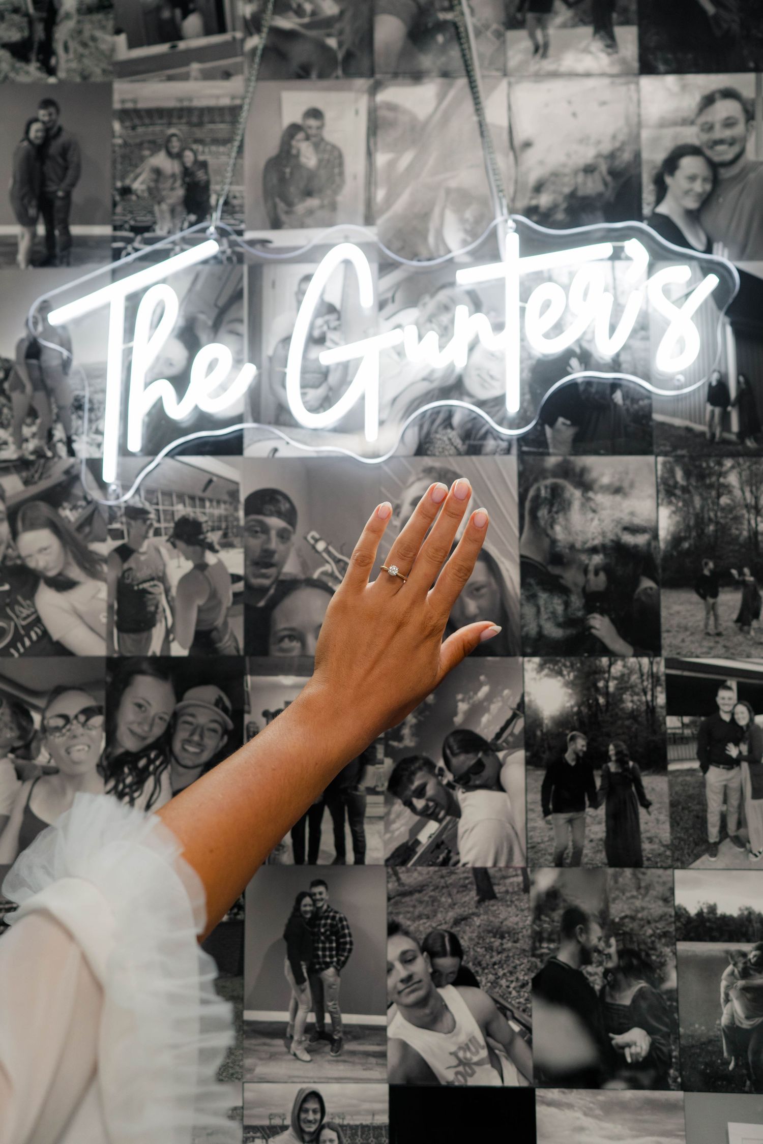Bride showing engagement ring near neon The Gunters sign surrounded by black and white photo collage.