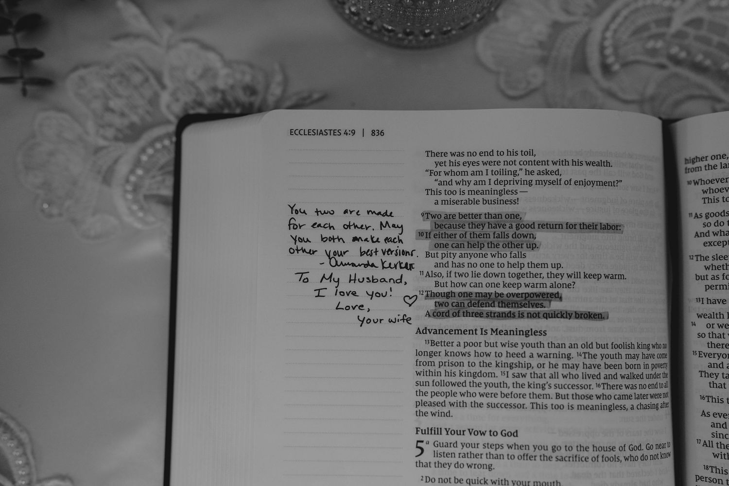 Black and white photo of open Bible with handwritten wedding vow inscription to husband and wife.