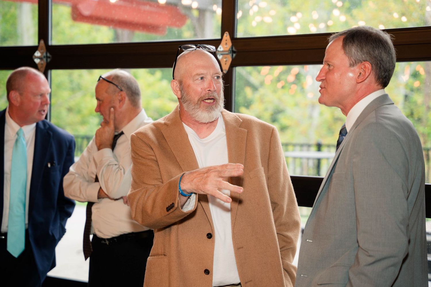 Men in business casual attire engaged in conversation at an indoor networking event.