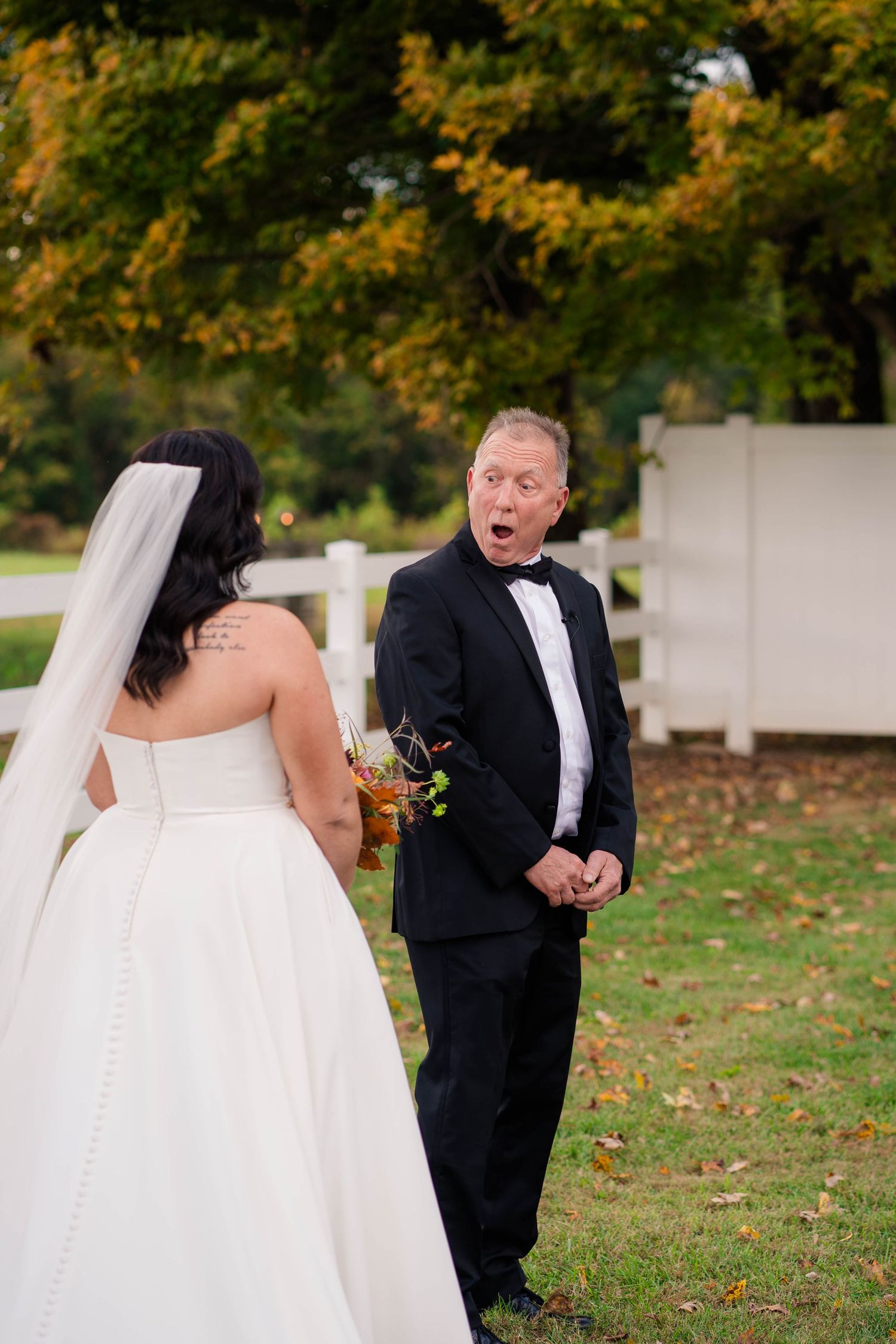 Groom reacts with surprise and awe during outdoor first look with bride at fall wedding.
