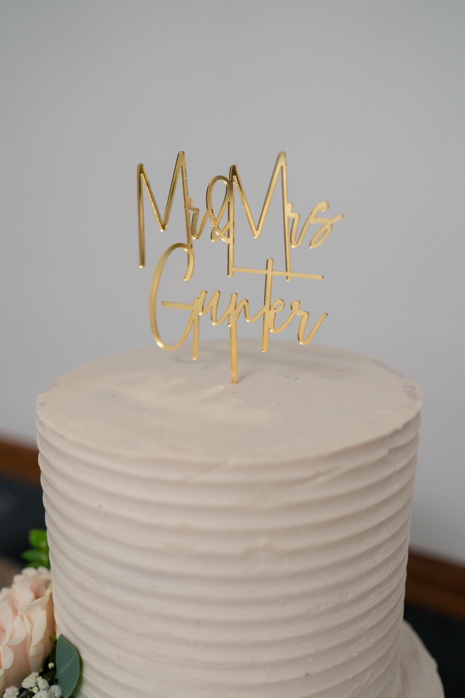 White wedding cake with gold Mr and Mrs Gunter cake topper.