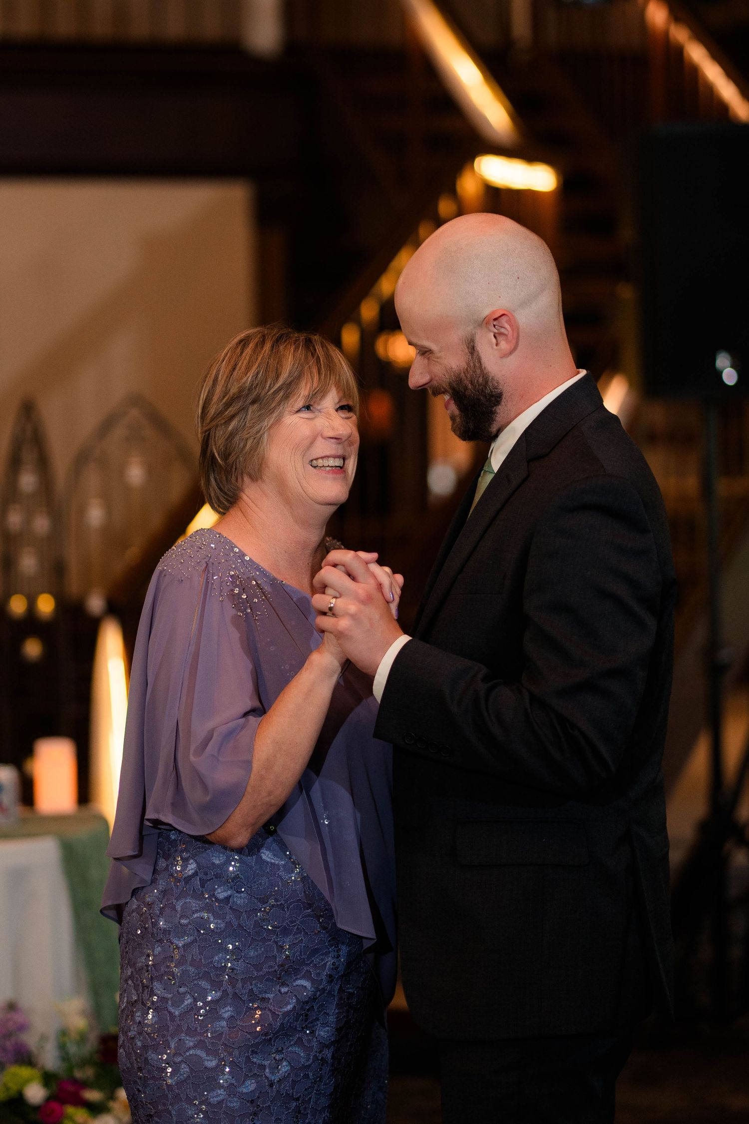 Groom shares a tender mother-son dance at elegant indoor wedding reception venue.