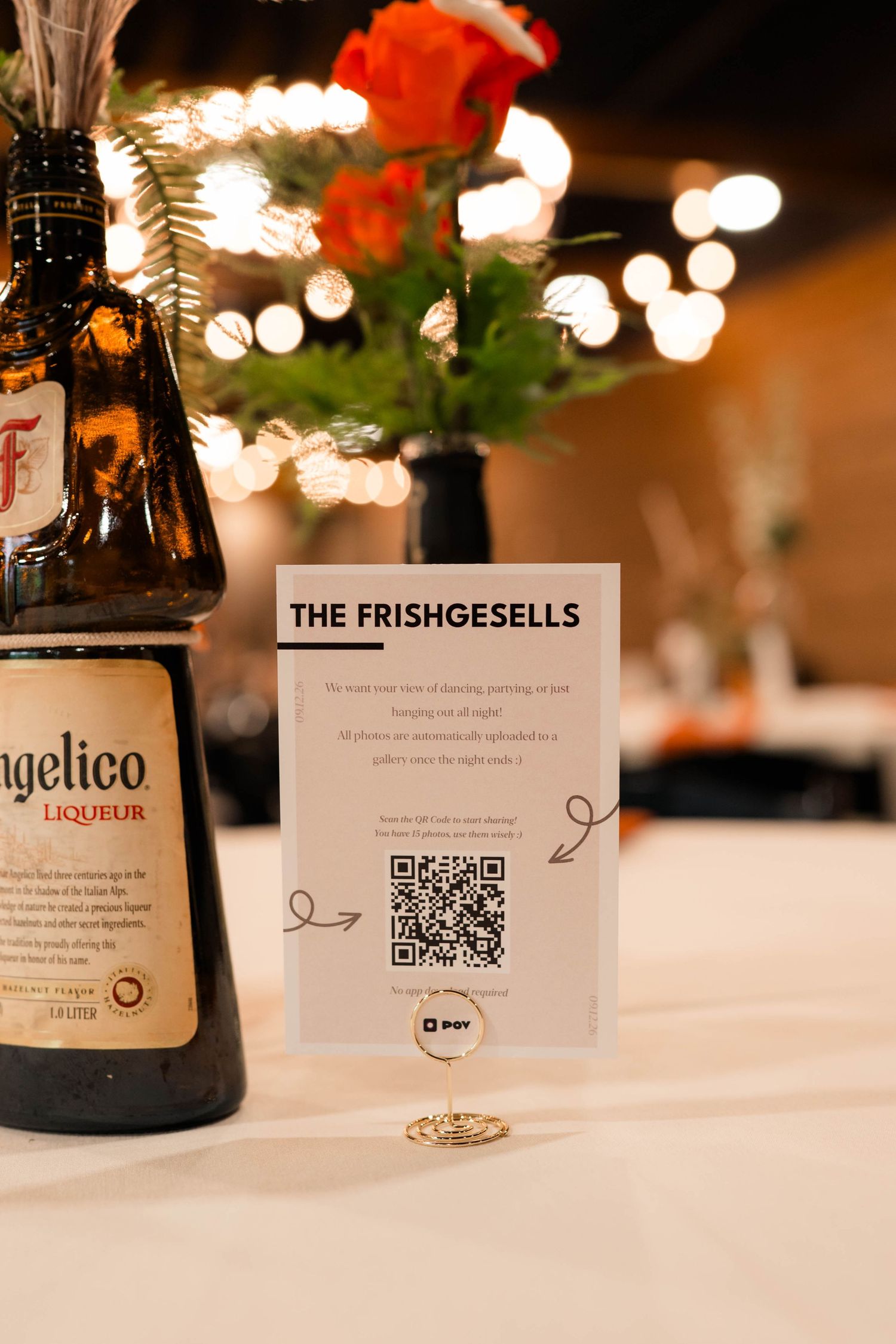Frangelico liqueur bottle beside Frishgesells wedding photo sharing QR code card on reception table.