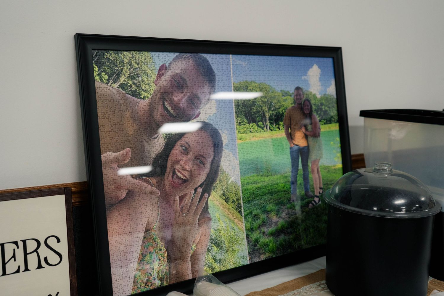 Framed wedding engagement photo collage displayed on table with couple selfie and outdoor portrait.