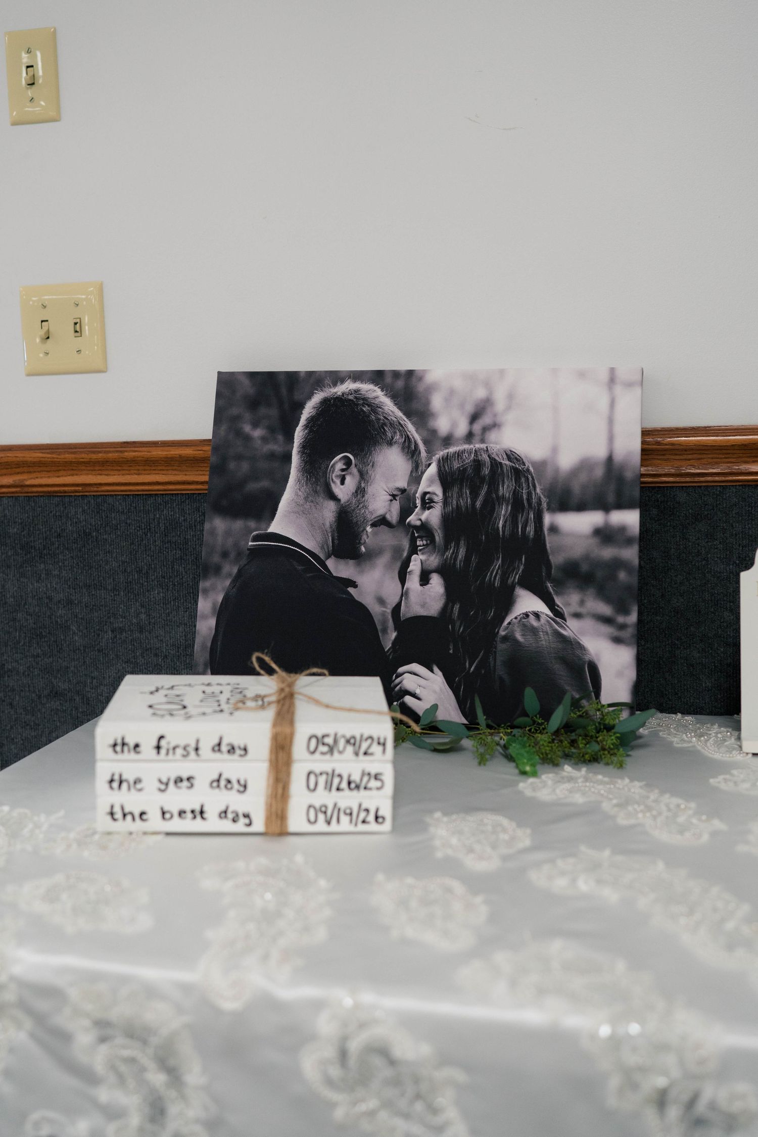 Wedding display with black and white couple portrait and milestone dates box reading first day, yes day, best day.