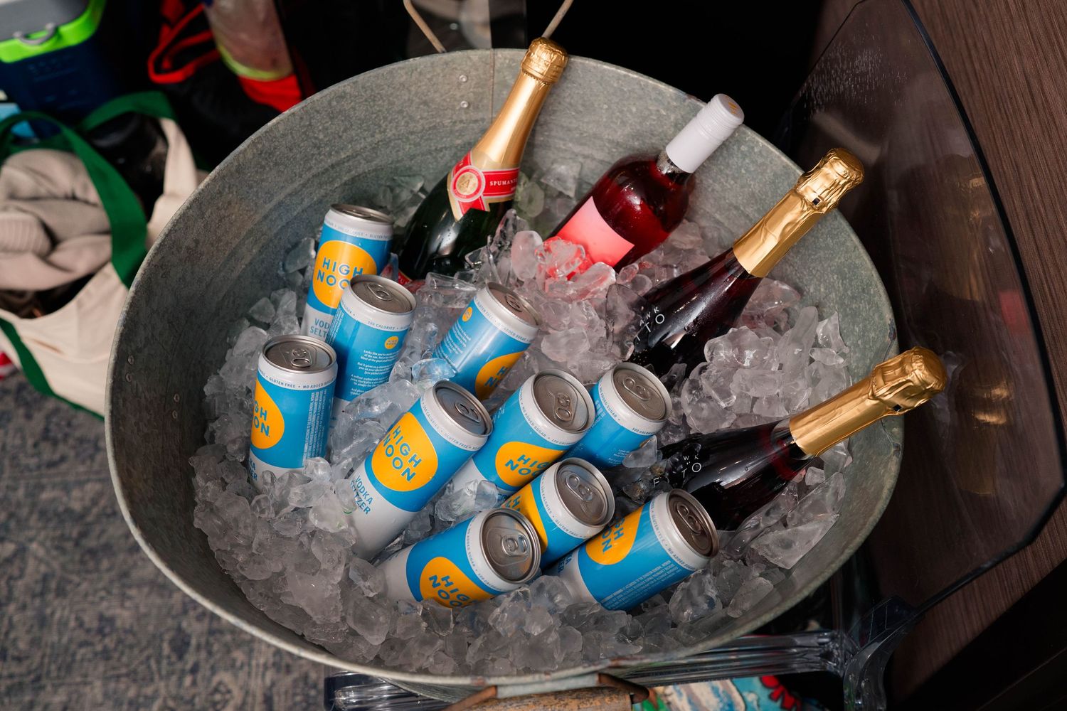 Ice bucket filled with champagne bottles and canned beverages at a wedding reception celebration.