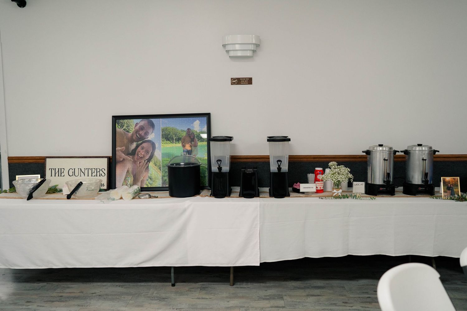 Wedding reception beverage station with dispensers, coffee urns, and The Gunters family photo display.