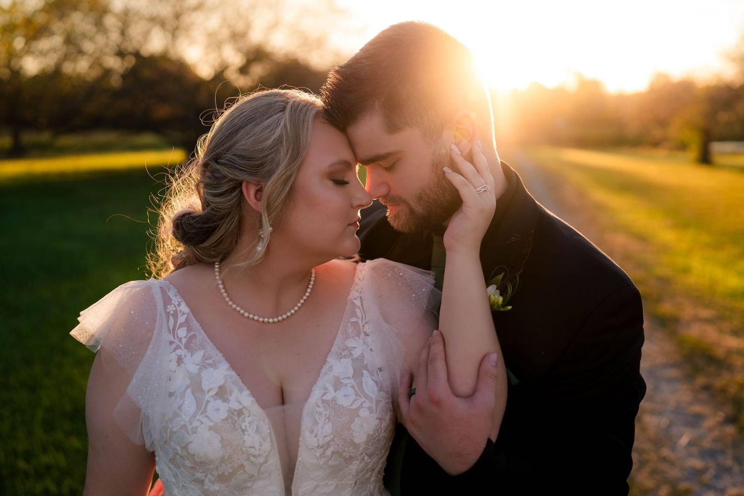 Bride and groom share an intimate golden hour moment outdoors at sunset.