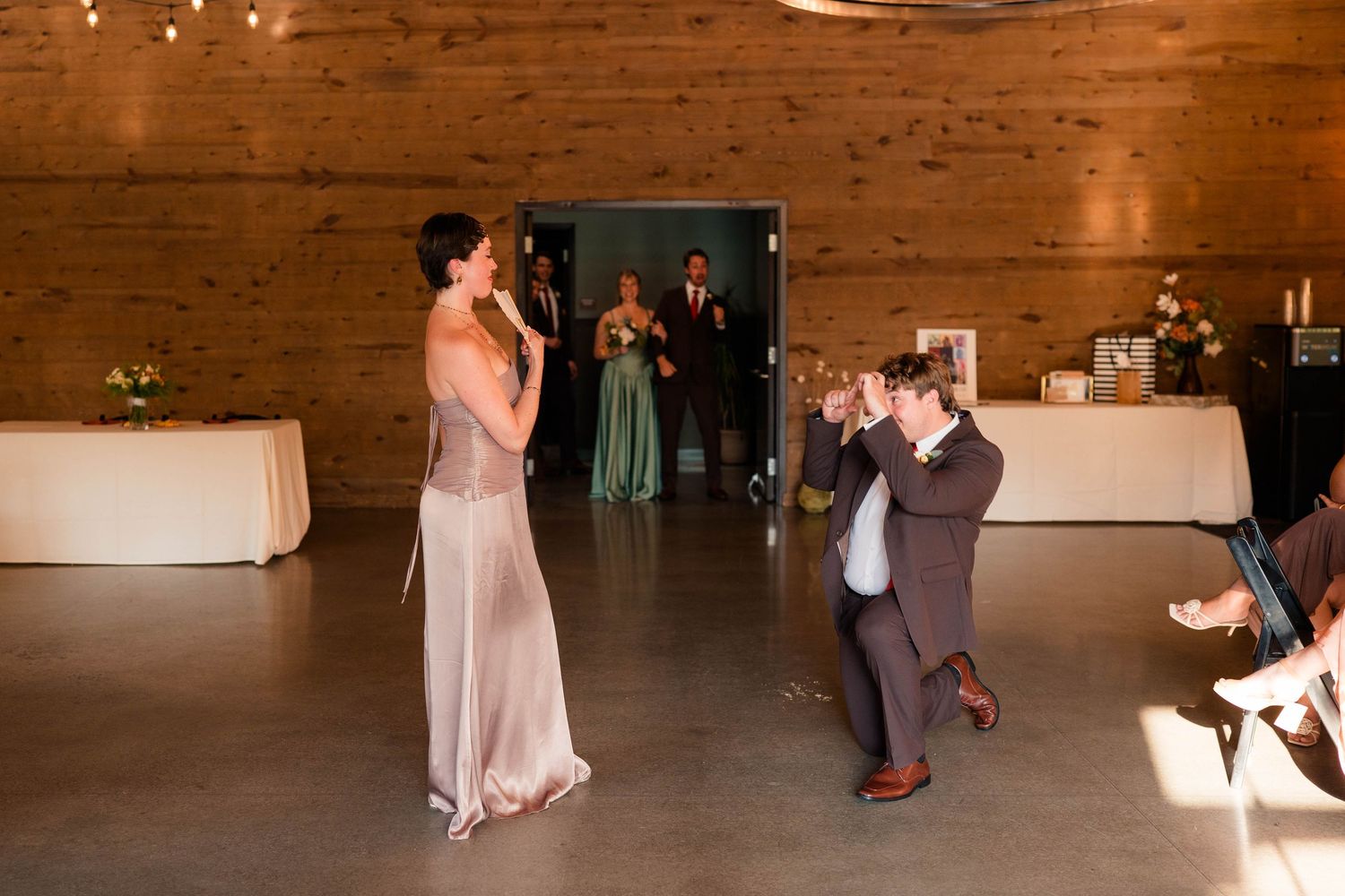 Wedding guest performs a surprise song on the dance floor while groom reacts with delight.