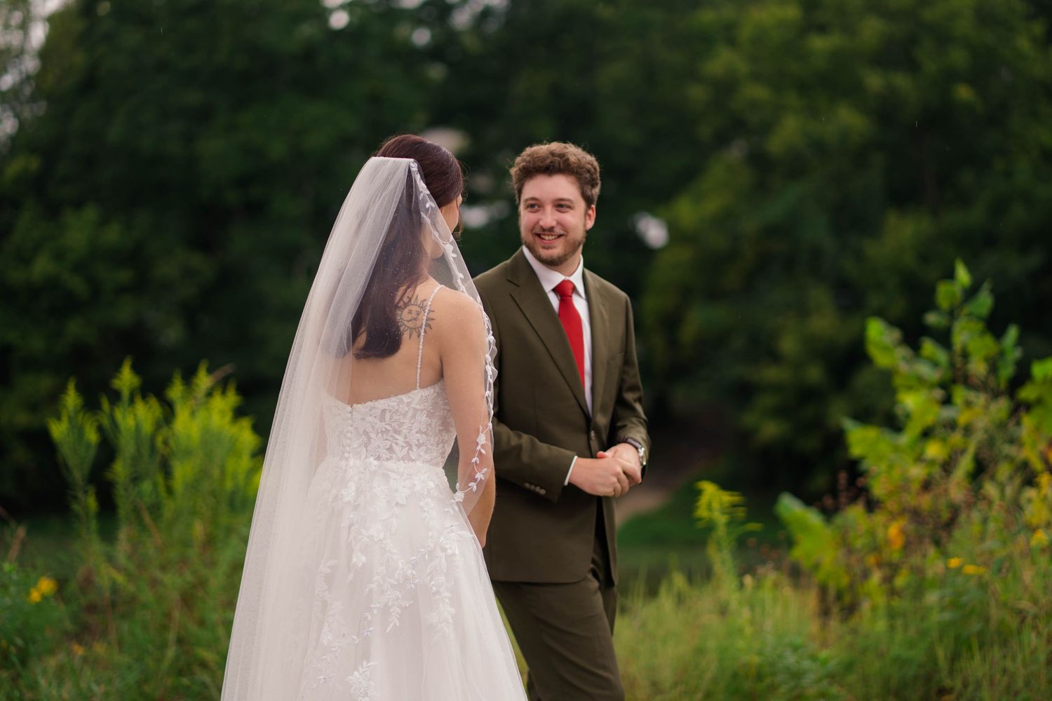 Bride and groom sharing a romantic first look outdoors at wedding.
