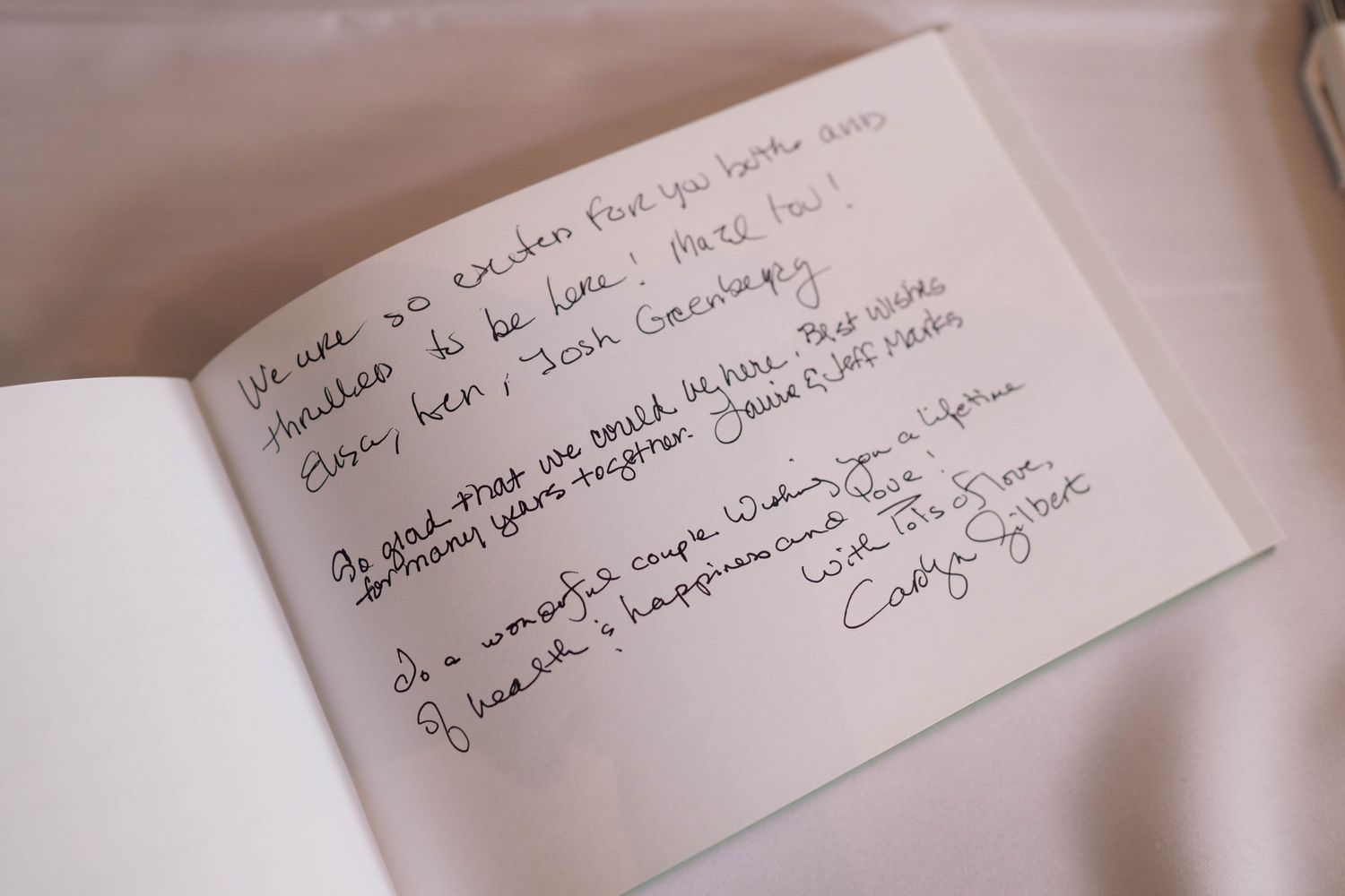 Handwritten congratulatory message in a guest book at a special celebration event.