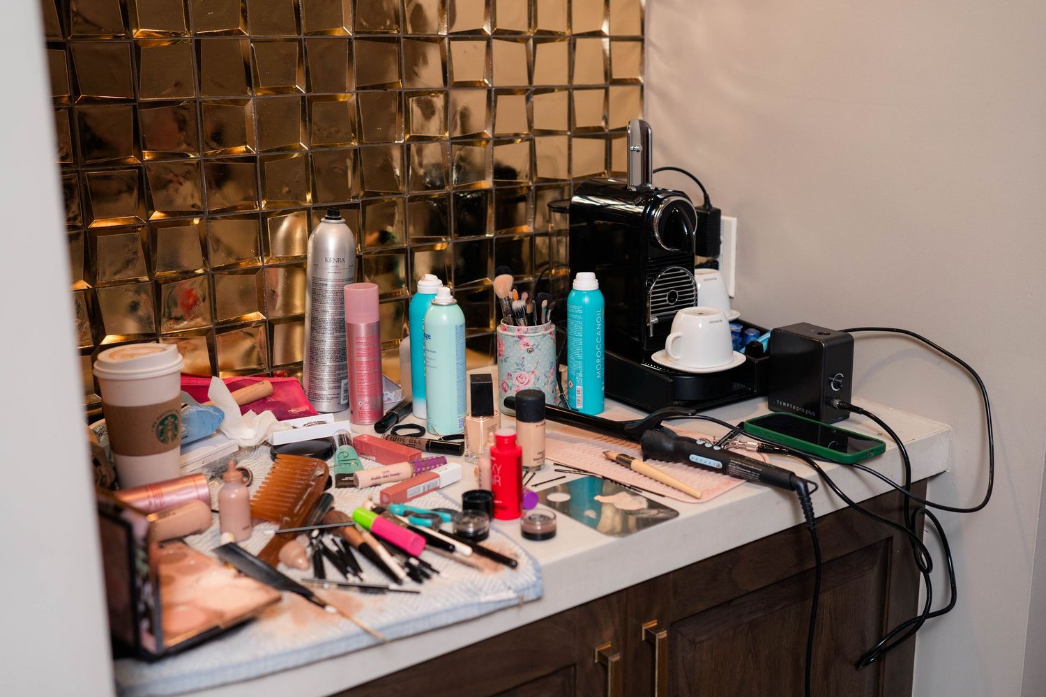 Wedding makeup station with beauty products, hair tools, and cosmetics on a vanity.
