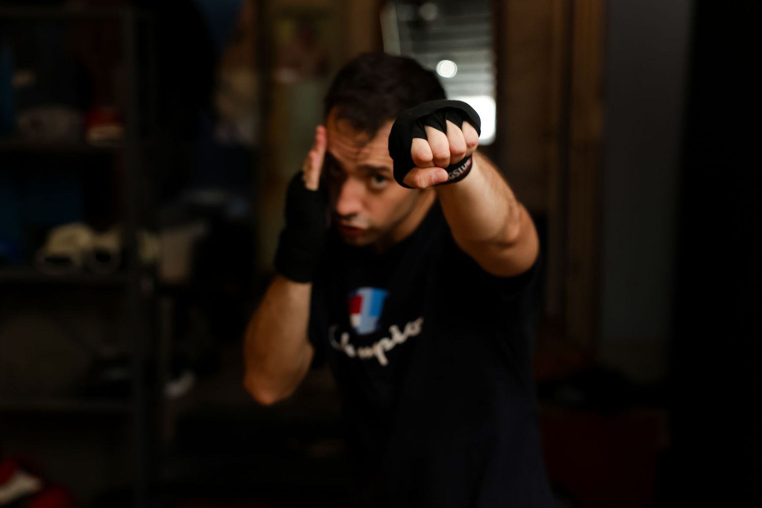 Male boxer in black shirt throwing a punch during training in dark gym.
by Andrew Fein Photography - Family and Newborn Photo