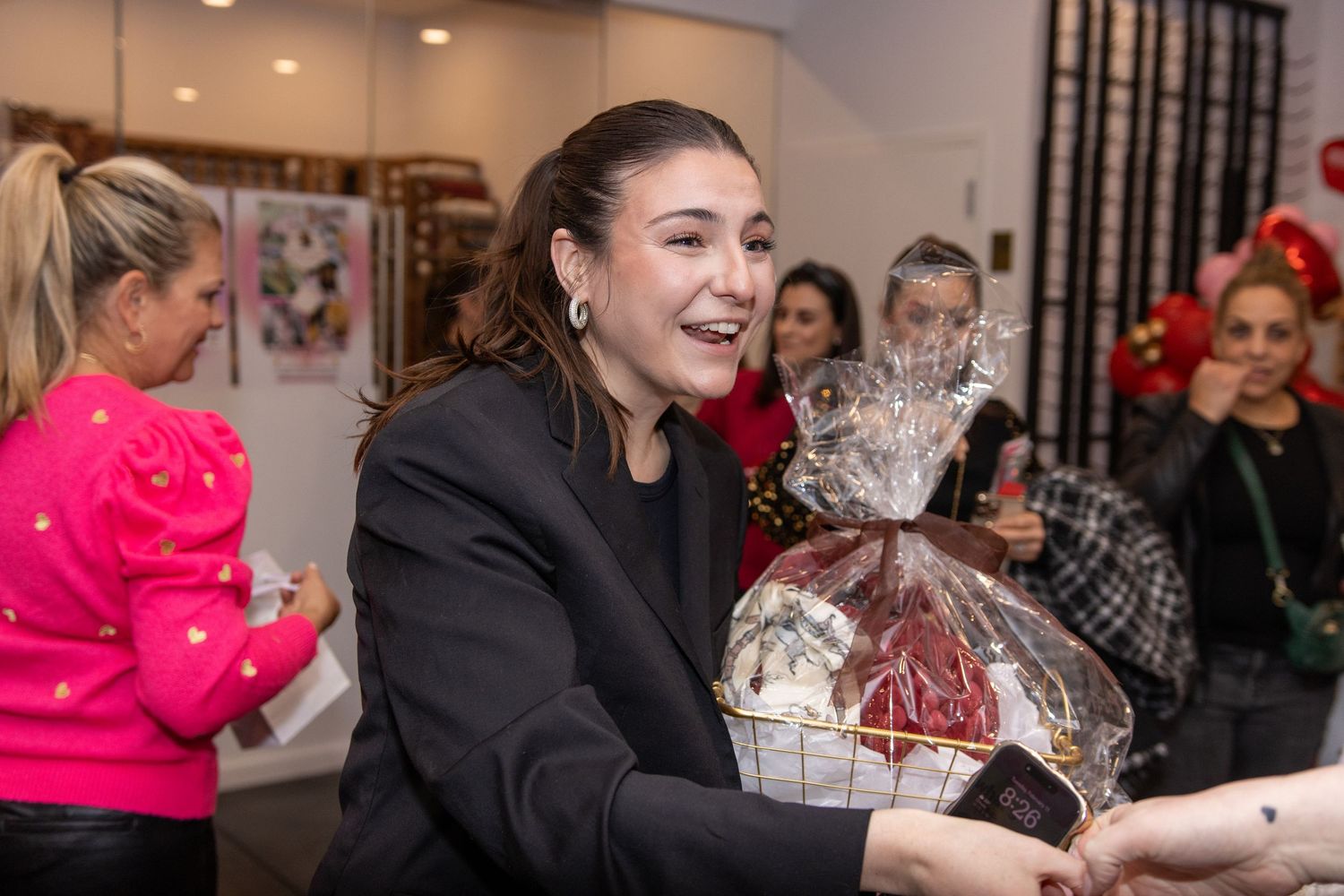 Woman smiling while holding a large gift basket wrapped in cellophane at an indoor event.
by Andrew Fein Photography - Family and Newborn Ph