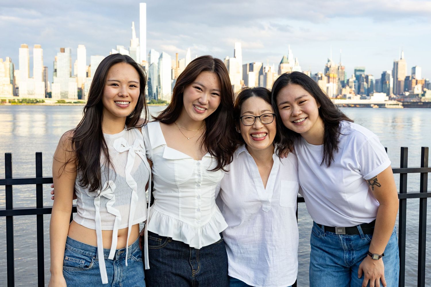 Four smiling Asian women pose together with the NYC skyline and Hudson River in the background.
by Andrew Fein Photography - Family