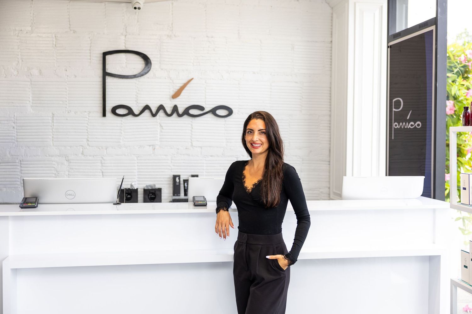 Smiling woman in black outfit leaning on white reception desk at Panico salon.
by Andrew Fein Photography - Family and Newborn Photo