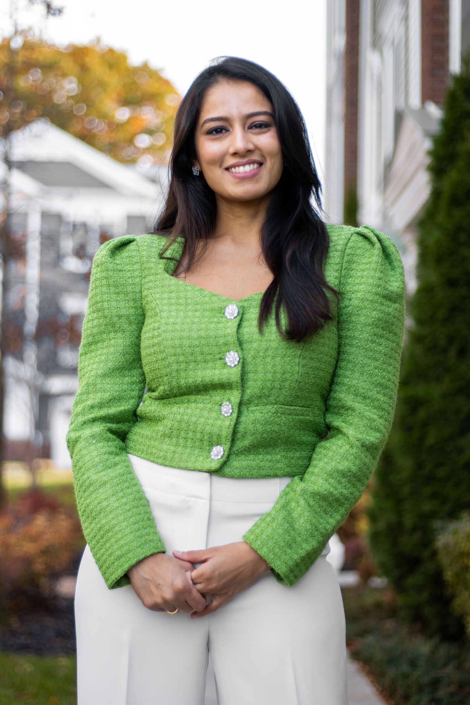Smiling woman in a green tweed blazer and white pants poses outdoors in a residential neighborhood.
by Andrew Fein Photography - Family and