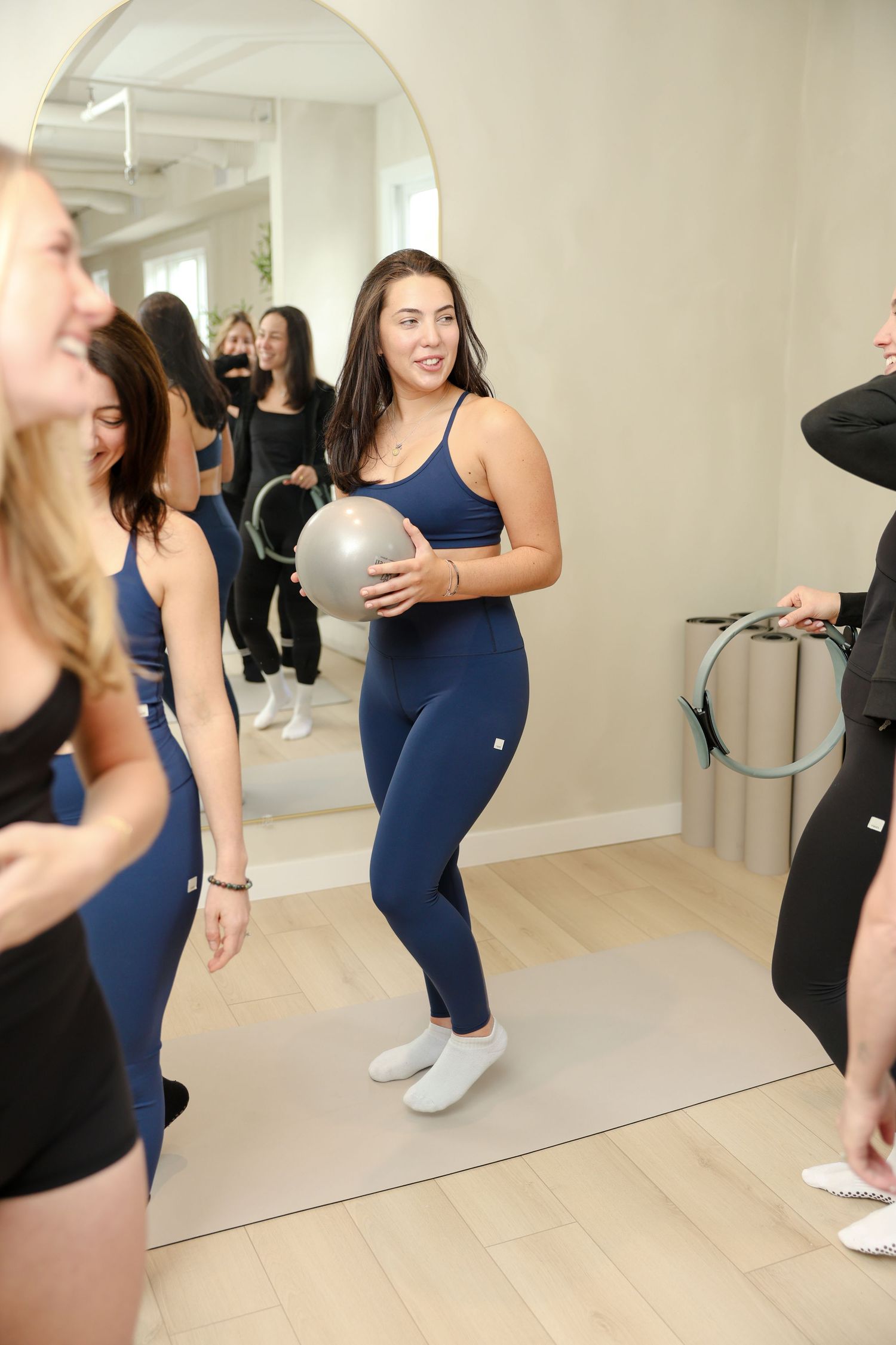 Women in navy activewear hold exercise balls in a bright fitness studio with mirrored walls.
by Andrew Fein Photography - Family and Newborn