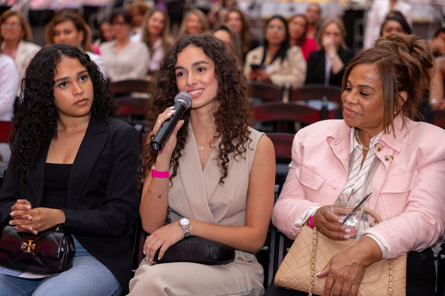 Three women sitting together at an event, one speaking into a microphone.
by Andrew Fein Photography - Family and Newborn Photo