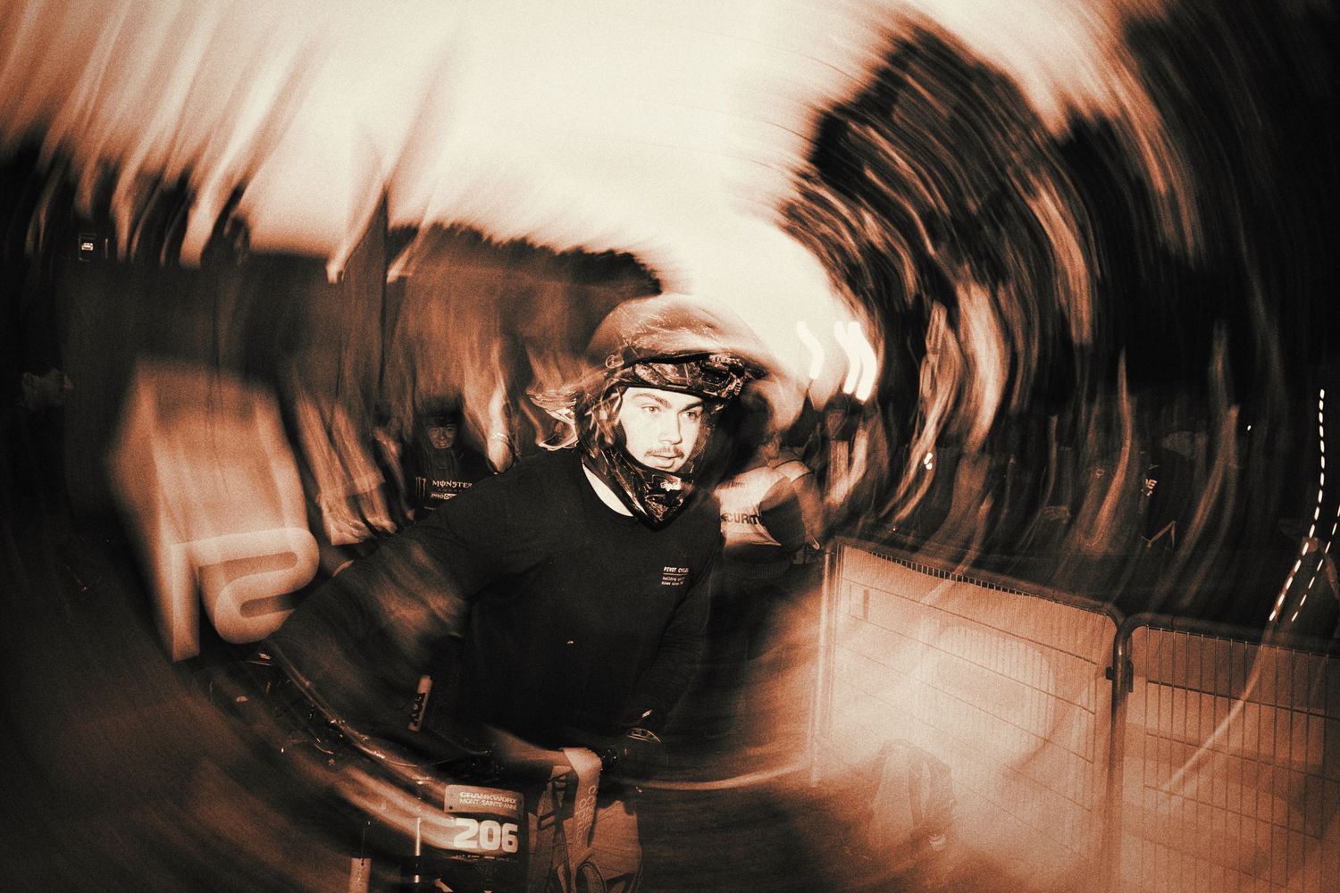 Motion blur action shot of a mountain bike athlete with swirling light effects by Dave Clément, Québec.