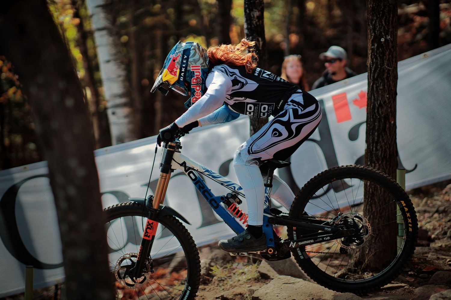 Gracey Hemstreet in colorful gear navigates at Mont-Sainte-Anne UCI downhill by Dave Clément, Québec.