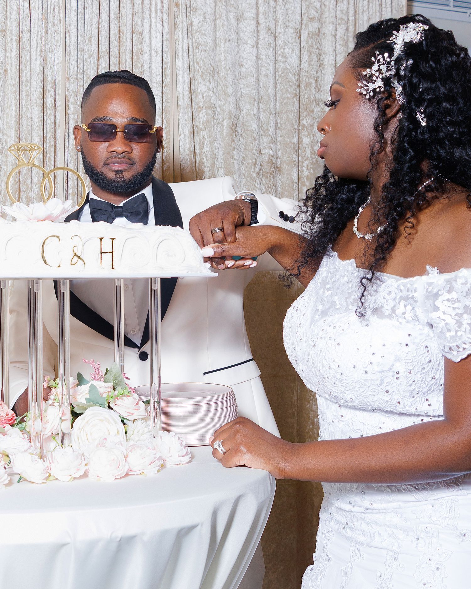 Bride and groom cutting their wedding cake monogrammed with C&H at elegant reception.