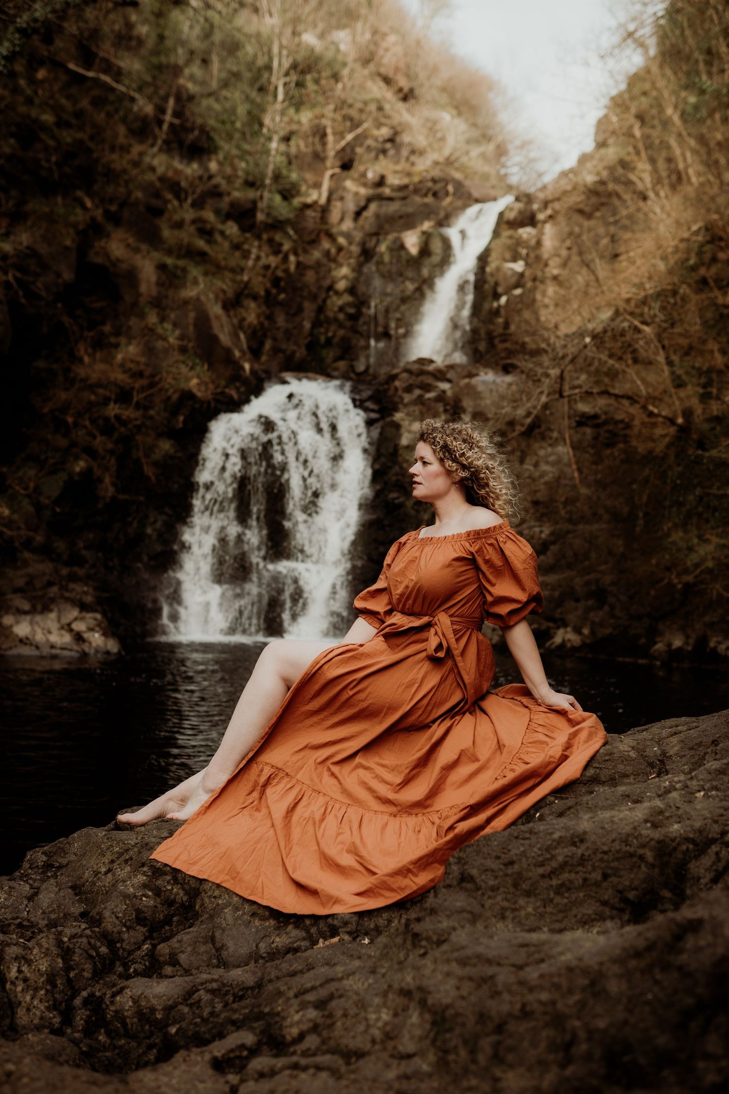 Vrouwenportret in de natuur bij verborgen waterval op Isle of Skye, Schotland