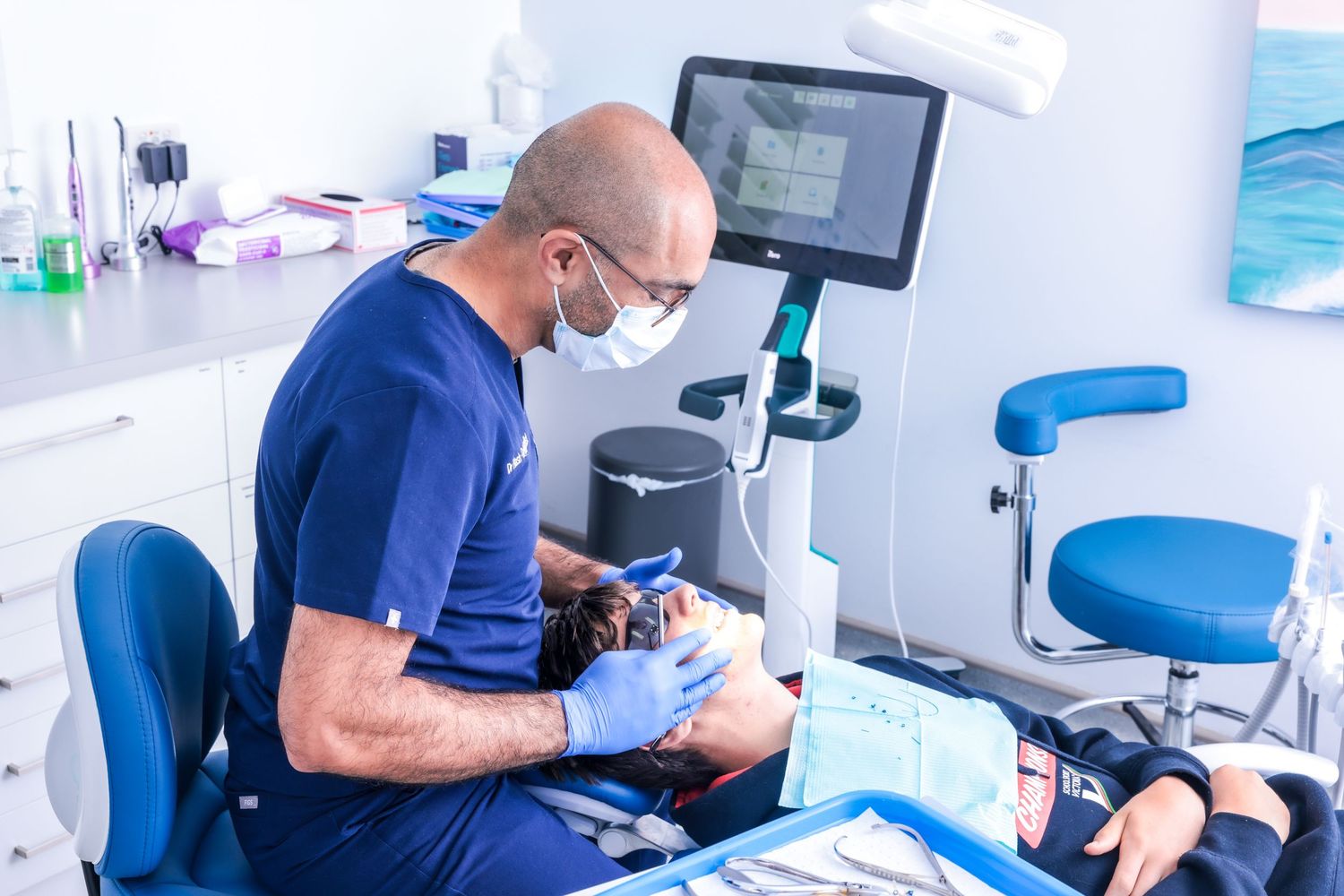 Photograph of a dentist treating a patient for the Braces N Faces brand.