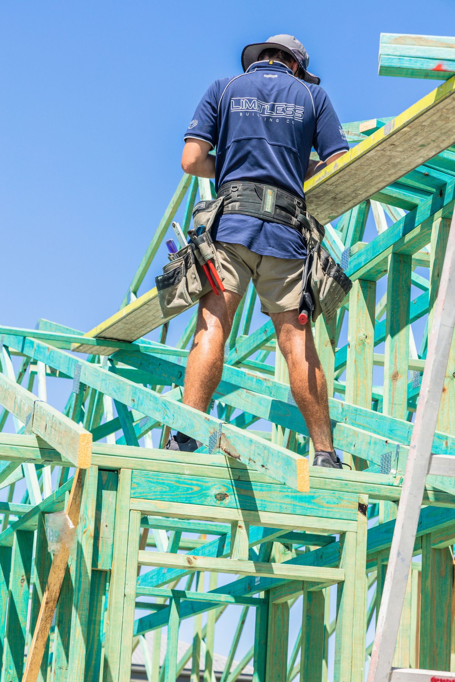 Construction photograph of a tradesperson working on a house frame at Banksia Beach.